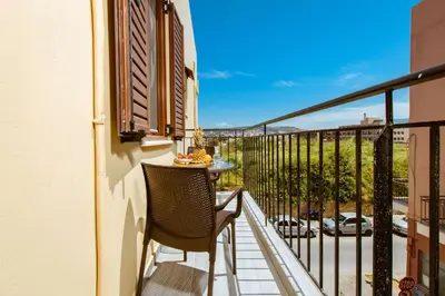 a balcony with a table and chairs and a view at Deluxe Suites in Chania Town