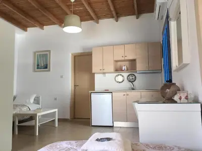 a kitchen with white cabinets and a white refrigerator at Sifis in Loutro