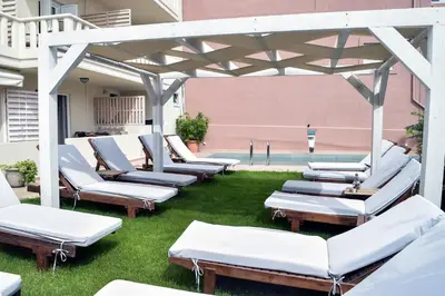 a row of chaise lounge chairs on a patio at Mithos Premium Rooms in Agia Marina Nea Kydonias