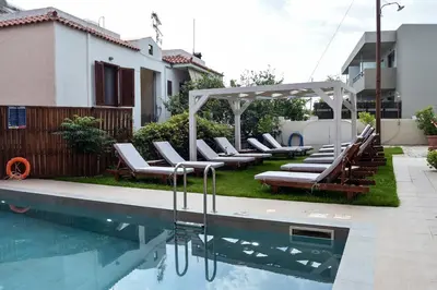 a pool with lounge chairs and a gazebo at Mithos Premium Rooms in Agia Marina Nea Kydonias