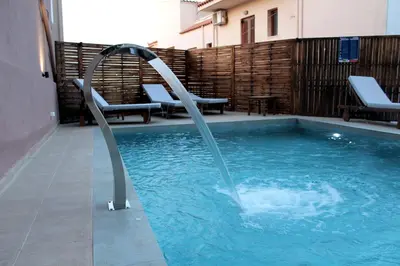 a swimming pool with a water slide in a building at Mithos Premium Rooms in Agia Marina Nea Kydonias