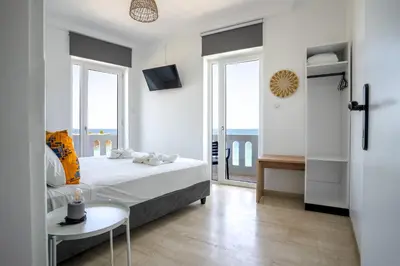 a bedroom with a bed and a view of the ocean at Kumba At Koum Kapi in Chania Town