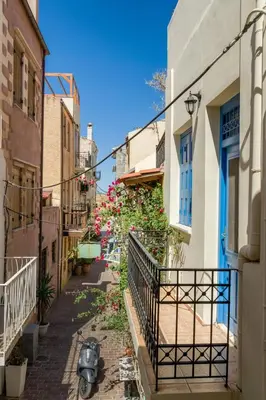 an alley in an old town with a scooter parked on the street at Revellino del Porto, Historic Residence in Chania Town