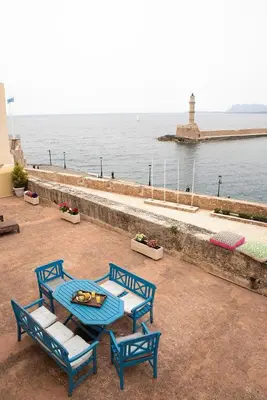 four blue chairs and a table with a view of the water at Revellino del Porto, Historic Residence in Chania Town