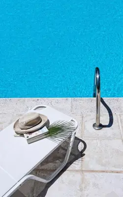 a hat sitting on a chair next to a pool at Villa Pefki in Chania Town