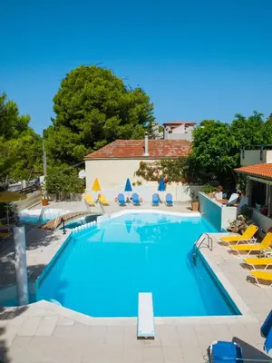 a large swimming pool with chairs and a building at Villa Pefki in Chania Town