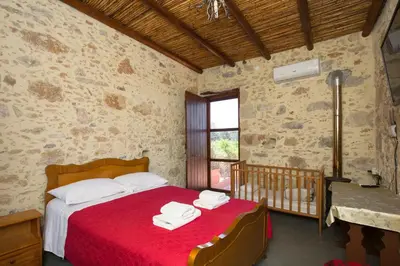 a bedroom with a bed with a red blanket at Sofiana's Garden Retreat with Private Pool in Drapaniás