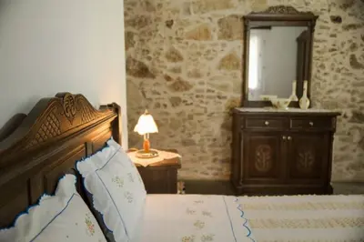 a bedroom with a bed and a dresser and a mirror at Sofiana's Garden Retreat with Private Pool in Drapaniás