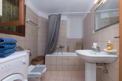 a bathroom with a sink and a bath tub at Sofiana's Garden Retreat with Private Pool in Drapaniás