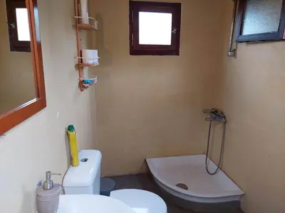 a bathroom with a white toilet and a sink at Sofiana's Garden Retreat with Private Pool in Drapaniás