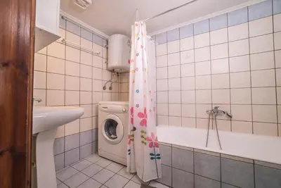 a bathroom with a washing machine and a shower curtain at Mamis Studio in Kissamos