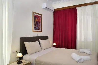 a bedroom with a bed and a red curtain at Aristea's Apartment 1st Floor in Chania Town