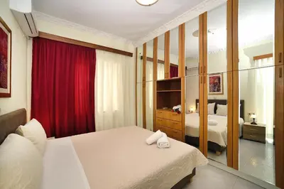 a bedroom with a bed and a red curtain at Aristea's Apartment 1st Floor in Chania Town