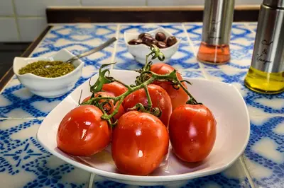 a white bowl of tomatoes on a table at Casa Veneziana in Chania Town