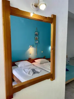 a mirror reflecting a bed in a room at Panorama Rooms in Agia Roumeli