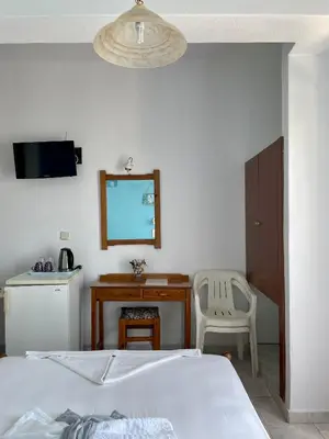 a bedroom with a bed and a desk and a mirror at Panorama Rooms in Agia Roumeli