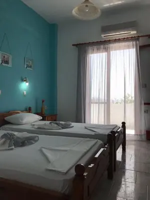 two twin beds in a room with a window at Panorama Rooms in Agia Roumeli