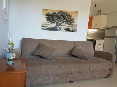 a couch in a living room with a painting on the wall at Elia Guesthouse - Kissamos in Kissamos