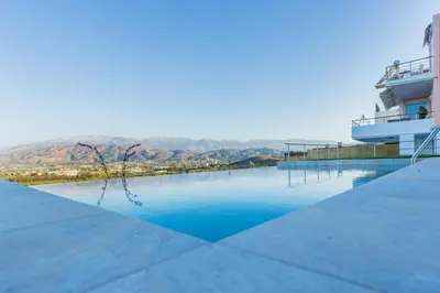 a swimming pool with a cruise ship in the background at Villa Oasis in Galatás