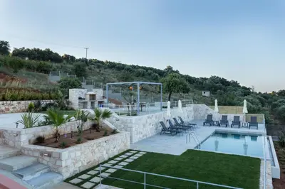 a backyard with a swimming pool and a patio with chairs at Villa Oasis in Galatás
