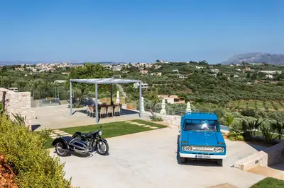 a blue car and a motorcycle parked in a driveway at Villa Oasis in Galatás