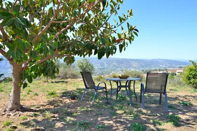 a table and chairs sitting under a tree at Feels like home in Chania Town