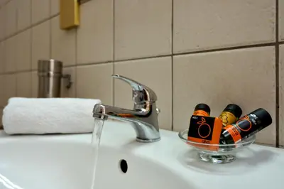 a bathroom sink with a glass bowl filled with wine bottles at Feels like home in Chania Town