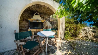 a table and chairs in front of a stone oven at Ilios Village in Stalos