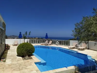a swimming pool with a view of the ocean at Ilios Village in Stalos