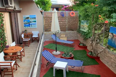 a patio with chairs and tables and an umbrella at Your Home in Kato Daratso