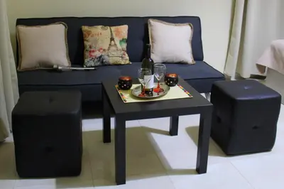 a living room with a blue couch and a table and stool at Your Home in Kato Daratso