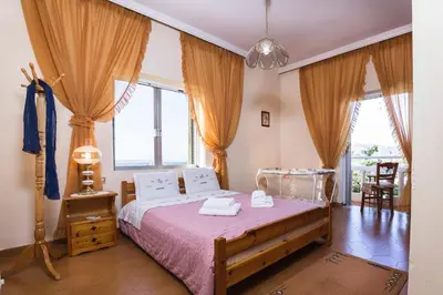 a bedroom with a bed with a pink bedspread at Villa Stefania - with Sea View Terrace in Drapaniás