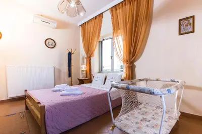 a bedroom with a bed and a chair in it at Villa Stefania - with Sea View Terrace in Drapaniás