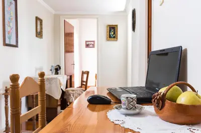 a laptop computer sitting on a wooden table with a basket of fruit at Villa Stefania - with Sea View Terrace in Drapaniás