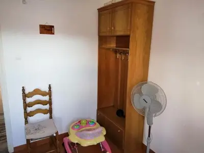 a room with a chair a fan and a cabinet at Villa Stefania - with Sea View Terrace in Drapaniás