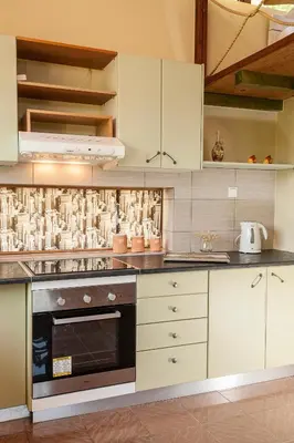 a kitchen with white cabinets and a stove top oven at Filio House in Stalos