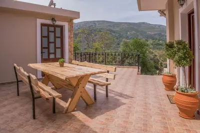 a wooden table and chairs on a patio at Marika Traditional Home in Élos