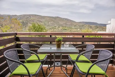 a table and chairs on a balcony with mountains at Marika Traditional Home in Élos