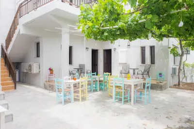a patio with tables and chairs in front of a building at Stellar Apartments I in Plataniás