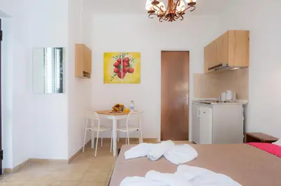 a room with a bed and a table and a kitchen at Stellar Apartments I in Plataniás
