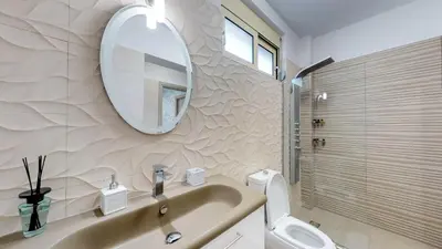 a bathroom with a sink and a mirror and a toilet at Liberty & Freedom Luxury Villa-heated pool in Plataniás