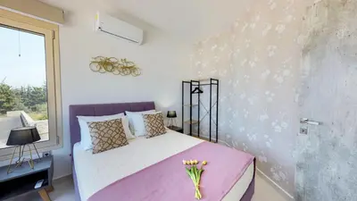 a bedroom with a pink bed and a window at Liberty & Freedom Luxury Villa-heated pool in Plataniás