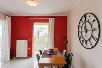 a dining room with a table and a clock on the wall at Thalassa Old Town Apartment in Chania Town