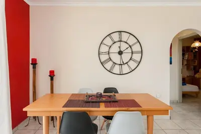 a dining room with a table and a clock on the wall at Thalassa Old Town Apartment in Chania Town