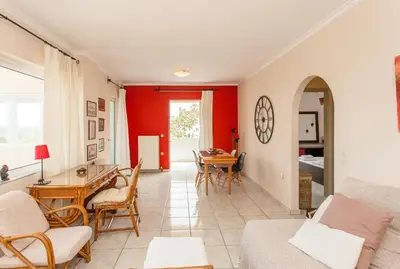 a living room with red walls and a table and chairs at Thalassa Old Town Apartment in Chania Town