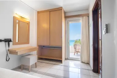 a bedroom with a door leading to the ocean at Pal Beach in Palaiochóra