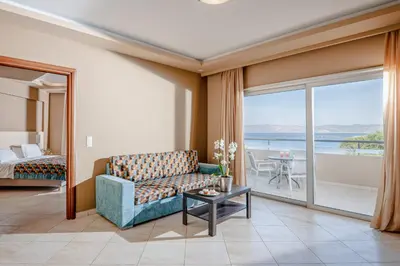 a living room with a couch and a view of the ocean at Molos Bay Hotel in Kissamos