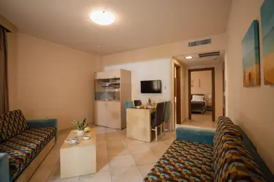 a living room with two couches and a kitchen at Molos Bay Hotel in Kissamos