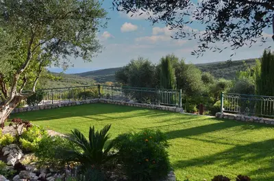 a garden with a large lawn with a fence at Villa Europa - Western Crete - Chania in Darmarochori