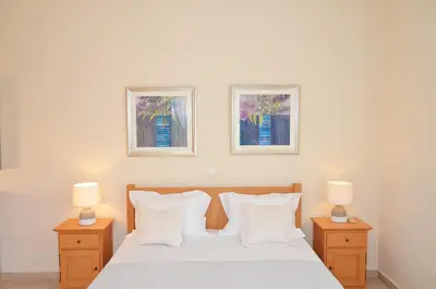 a bedroom with a bed with two pictures on the wall at Villa Europa - Western Crete - Chania in Darmarochori